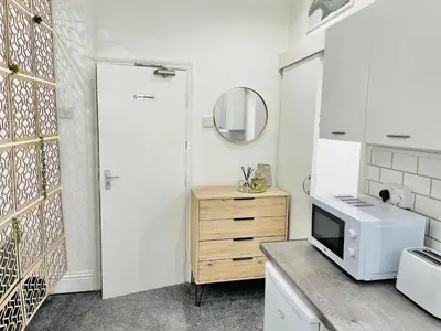 a kitchen with a microwave and a counter with a sink at Lovely Estelle Studio Apartment by CityNest in Blackpool