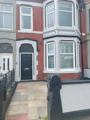 a brick house with a black door and a driveway at Lovely Estelle Studio Apartment by CityNest in Blackpool