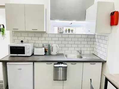 a kitchen counter with a microwave and a sink at Lovely Estelle Studio Apartment by CityNest in Blackpool