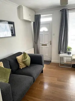 a living room with a couch and wooden floors at Burlington Cottage - Ulverston, Lake District. in Ulverston