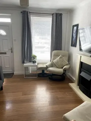 a living room with a chair and a window at Burlington Cottage - Ulverston, Lake District. in Ulverston