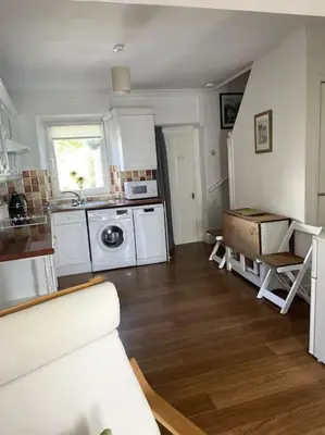 a kitchen with white appliances and a wooden floor at Burlington Cottage - Ulverston, Lake District. in Ulverston