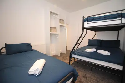 a bedroom with two bunk beds with blue sheets at Media Manor - Fully Refurbished in 2022 - Large 6 Bedrooms, 3 Bathrooms plus Media Games Room in Blackpool