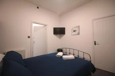 a bedroom with a blue bed with two towels on it at Media Manor - Fully Refurbished in 2022 - Large 6 Bedrooms, 3 Bathrooms plus Media Games Room in Blackpool