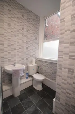 a bathroom with a sink and a toilet and a window at Media Manor - Fully Refurbished in 2022 - Large 6 Bedrooms, 3 Bathrooms plus Media Games Room in Blackpool