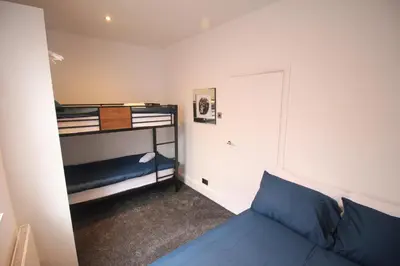 a small room with a bed and a bunk bed at Media Manor - Fully Refurbished in 2022 - Large 6 Bedrooms, 3 Bathrooms plus Media Games Room in Blackpool