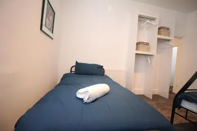 a bedroom with a blue bed with a white towel on it at Media Manor - Fully Refurbished in 2022 - Large 6 Bedrooms, 3 Bathrooms plus Media Games Room in Blackpool