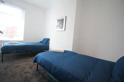 a bedroom with two beds and a window at Media Manor - Fully Refurbished in 2022 - Large 6 Bedrooms, 3 Bathrooms plus Media Games Room in Blackpool
