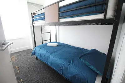 a bedroom with a bunk bed with blue sheets at Media Manor - Fully Refurbished in 2022 - Large 6 Bedrooms, 3 Bathrooms plus Media Games Room in Blackpool