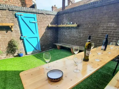 a wooden table with glasses and a bottle of wine at Anfield Haven in Liverpool