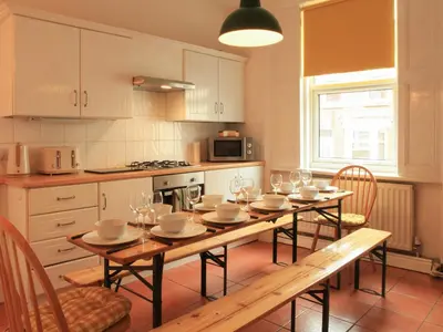 a kitchen with a table with wine glasses on it at Anfield Haven in Liverpool