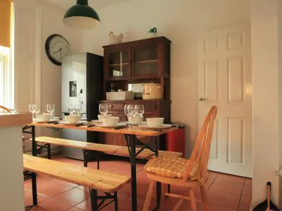 a kitchen with a table and chairs and a clock at Anfield Haven in Liverpool