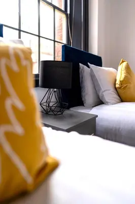 a room with a bed and a desk with a laptop at The Cavern Quarter Aparthotel by UStay in Liverpool