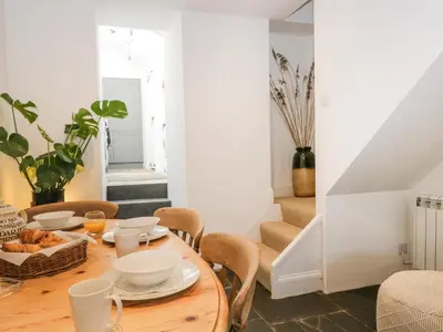 a dining room with a wooden table and chairs at Sandacre Cottage in Ulverston