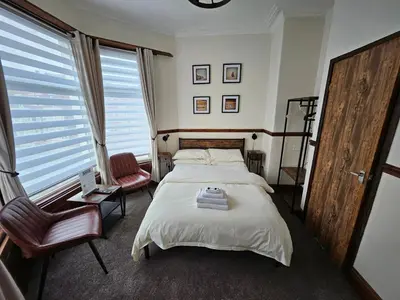 a bedroom with a bed and a chair at Rendezvous Bar & Rooms - ADULTS ONLY in Blackpool