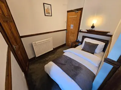a small bedroom with a bed in a room at Rendezvous Bar & Rooms - ADULTS ONLY in Blackpool