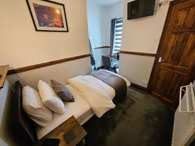 a hotel room with a bed and a wooden door at Rendezvous Bar & Rooms - ADULTS ONLY in Blackpool