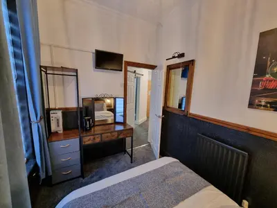 a bedroom with a bed and a desk and a mirror at Rendezvous Bar & Rooms - ADULTS ONLY in Blackpool