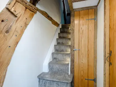 a staircase in a house with a wooden door at The Restored Cottage in Eccleston