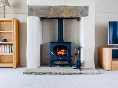 a fireplace in a living room with a stove at The Restored Cottage in Eccleston