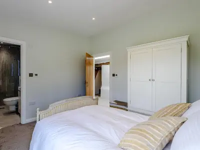 a bedroom with a white bed and a mirror at The Restored Cottage in Eccleston
