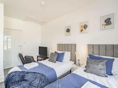 a bedroom with two beds and a tv on the wall at Sea View Apartment Two - Uk36847 in Blackpool