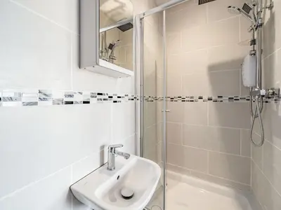 a white bathroom with a sink and a shower at Sea View Apartment Two - Uk36847 in Blackpool