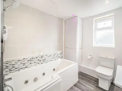 a white bathroom with a tub and a toilet at Sea View Apartment Two - Uk36847 in Blackpool