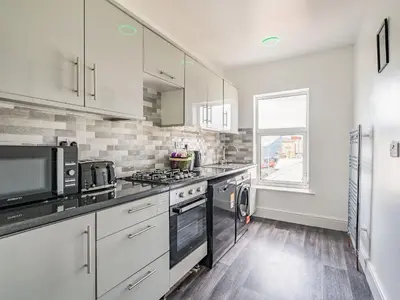a kitchen with white cabinets and a stove top oven at Sea View Apartment Two - Uk36847 in Blackpool
