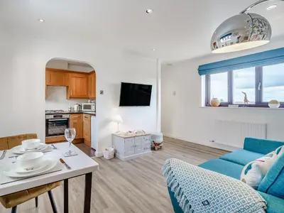 a living room with a blue couch and a table at The Birds Nest in Longridge