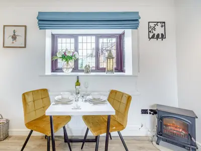 a dining room with a table and a fireplace at The Birds Nest in Longridge