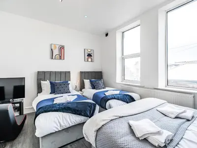 three beds in a room with white walls and windows at Sea View Apartment One - Uk36846 in Blackpool