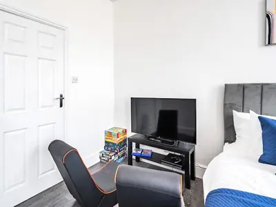 a bedroom with a bed and a chair and a television at Sea View Apartment One - Uk36846 in Blackpool