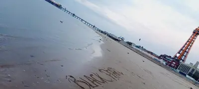 a message written in the sand on the beach at Black Pearl Luxury Apartments in Blackpool