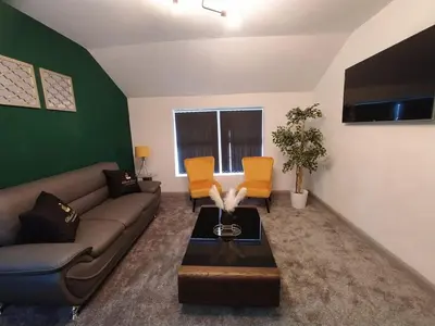 a living room with a couch and orange chairs at Black Pearl Luxury Apartments in Blackpool