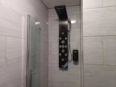 a shower with a remote control in a shower stall at Black Pearl Luxury Apartments in Blackpool