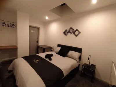 a bedroom with a bed with a teddy bear on it at Black Pearl Luxury Apartments in Blackpool