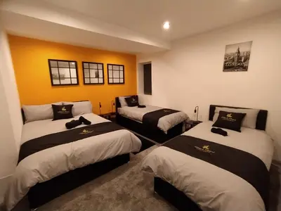 a room with three beds in a room at Black Pearl Luxury Apartments in Blackpool