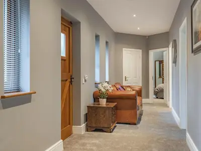 a living room with a brown couch and a table at Hoole Summer House in Elswick