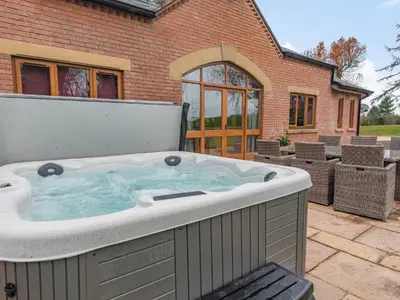 a large hot tub in a patio with a building at Hoole Summer House in Elswick