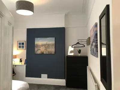 a bedroom with a navy blue accent wall at Bright Spacious 3-bed with office & patio, Preston in Preston