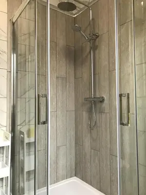a shower with a glass door in a bathroom at Bright Spacious 3-bed with office & patio, Preston in Preston