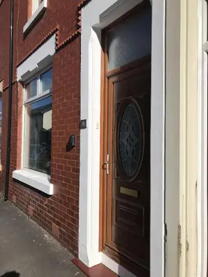 a brown door on a brick building with a window at Bright Spacious 3-bed with office & patio, Preston in Preston