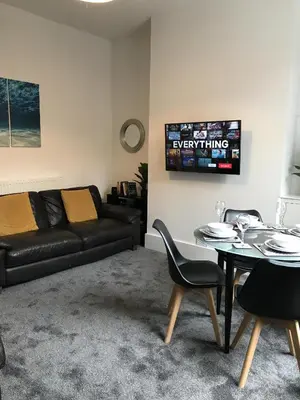 a living room with a couch and a table at Bright Spacious 3-bed with office & patio, Preston in Preston