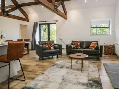 a living room with two couches and a table at Bank Hurst Coach House in Ulverston