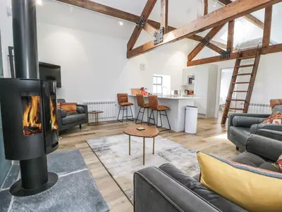 a living room with a fireplace in a loft at Bank Hurst Coach House in Ulverston