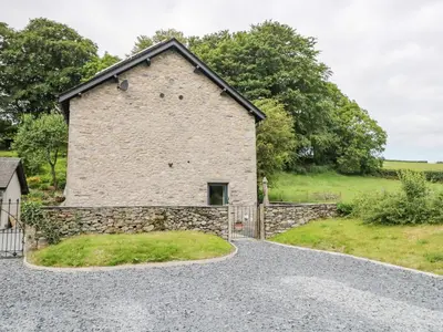 an external view of a stone building with a gate at Bank Hurst Coach House in Ulverston