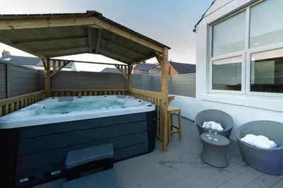 a hot tub under a pavilion on a patio at HOT TUB JACUZZI on private terrace FREE GATED PARKING sleeps 8 in Blackpool