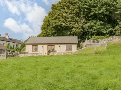 a house in the middle of a green field at Little Barn in Grange Over Sands