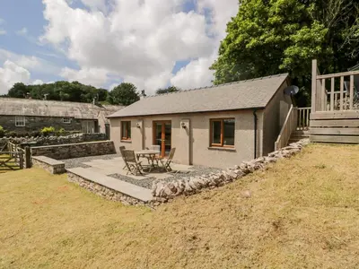 a small cottage with a patio and a table at Little Barn in Grange Over Sands